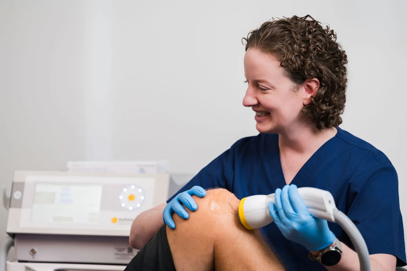 Dr. Foster giving a SoftWave treatment to a patient's knee